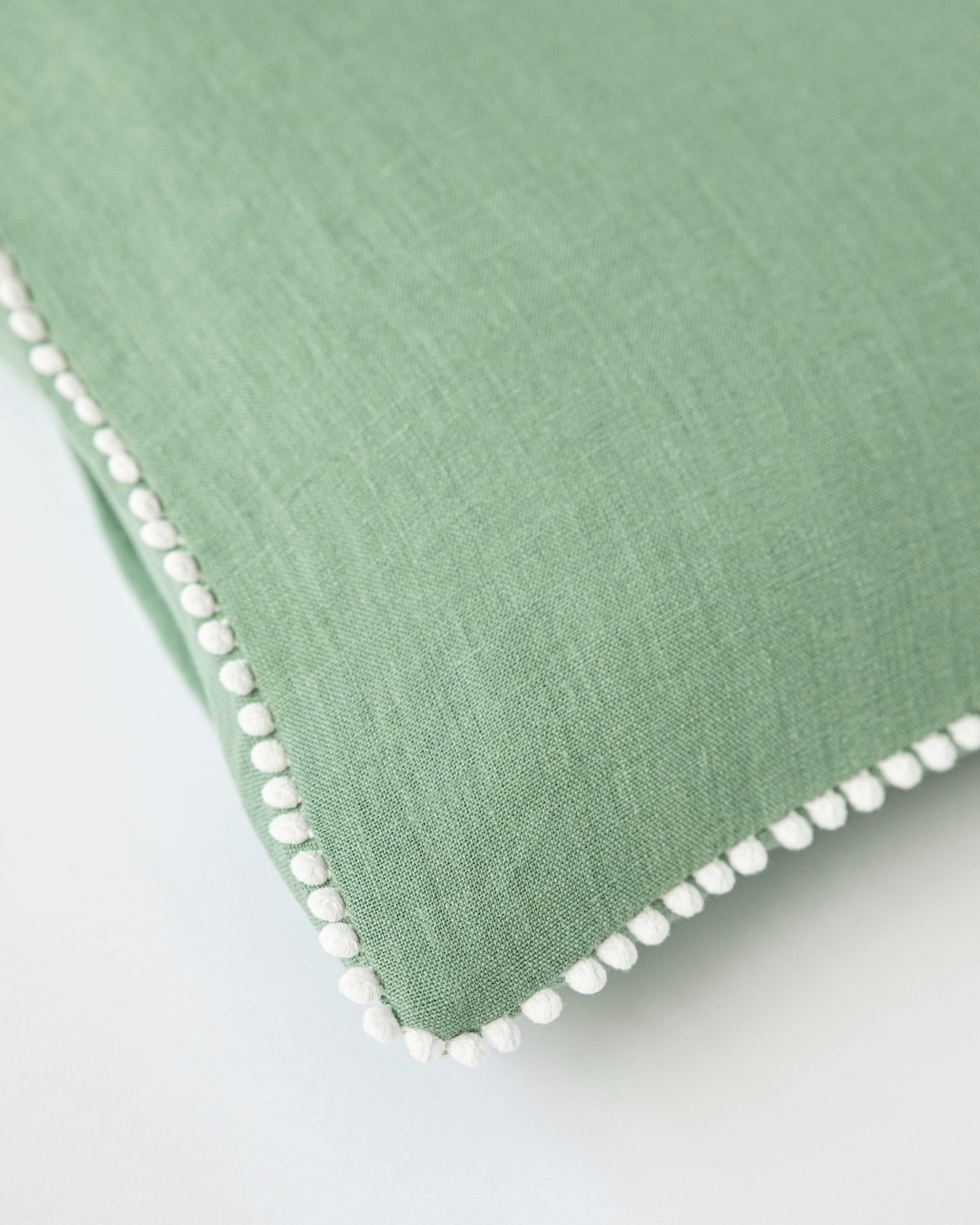 Cushion cover with pom poms in Matcha green - MagicLinen